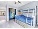 Comfortable bedroom with blue-themed bunkbeds, decorated with gray wood flooring and colorful Harry Potter themes at 730 Pope Dr, Erie, CO 80516