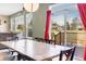 Dining area with large table, with view of back deck and yard through large windows and sliding doors at 730 Pope Dr, Erie, CO 80516