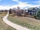 View of a two-story home with a wooden deck and fenced yard next to a walking path at 730 Pope Dr, Erie, CO 80516