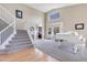 Bright foyer with high ceilings, elegant staircase, and hardwood floors transitioning to plush carpet at 730 Pope Dr, Erie, CO 80516