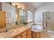 Well-lit bathroom with dual sinks, soaking tub, and a separate shower stall at 100 Apache Rd, Evergreen, CO 80439