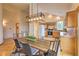 Dining area open to the kitchen, with a wood table and a modern light fixture for intimate gatherings at 100 Apache Rd, Evergreen, CO 80439