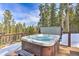 Outdoor hot tub on a wooden deck surrounded by a forest at 100 Apache Rd, Evergreen, CO 80439