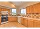 Well-lit kitchen with wood cabinets, tile backsplash, and a view of the outdoors for a pleasant cooking experience at 100 Apache Rd, Evergreen, CO 80439