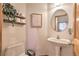 Cozy powder room featuring a pedestal sink, a round mirror, and stylish decor for guests' convenience at 100 Apache Rd, Evergreen, CO 80439