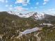 Scenic aerial view of mountain community with lake and snow-capped peaks on a sunny day at 72 Overlook Ct, Idaho Springs, CO 80452