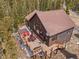 Aerial view of a log home featuring a large deck, seating and a hot tub at 72 Overlook Ct, Idaho Springs, CO 80452