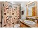 Bathroom features a decorative shower curtain, wood-look mirror, sink, and fixtures at 72 Overlook Ct, Idaho Springs, CO 80452