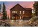 Charming log home with a two-car garage and inviting curb appeal against a colorful sky at sunset at 72 Overlook Ct, Idaho Springs, CO 80452