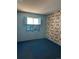 Cozy bedroom with blue carpet, matching blue wall and shutters, and wallpaper with historical design at 12879 E Oregon Dr, Aurora, CO 80012
