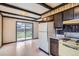 Kitchen with wood beamed ceilings, laminate floors, and access to the backyard at 12879 E Oregon Dr, Aurora, CO 80012