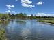 Scenic view of a pond with trees and blue skies with fluffy white clouds at 12879 E Oregon Dr, Aurora, CO 80012