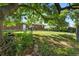 Spacious backyard with lush greenery, mature trees, and a view of the charming brick home and outdoor space at 8140 Pennsylvania Way, Denver, CO 80229