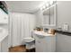 Bathroom featuring a white vanity, a mirror with lights, and a shower with white shower curtain at 8140 Pennsylvania Way, Denver, CO 80229