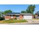 Charming brick home with a well-maintained lawn, solar panels, attached garage, and welcoming front porch at 8140 Pennsylvania Way, Denver, CO 80229