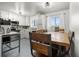 Well-lit kitchen with white cabinets, blue backsplash, and a dining area perfect for Gathering meals at 8140 Pennsylvania Way, Denver, CO 80229