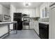 Updated kitchen with stainless steel appliances, gray tile floor, and ample storage space at 8140 Pennsylvania Way, Denver, CO 80229