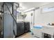 Laundry room with washer, dryer, utility sink, and shelving for supplies at 8140 Pennsylvania Way, Denver, CO 80229