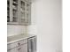 Stylish bar area featuring glass cabinets, a wine fridge, and subway tile backsplash at 27653 E Euclid Dr, Aurora, CO 80016