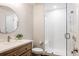 Modern bathroom featuring a wood vanity, stylish sink, and a glass-enclosed shower with white subway tile at 27653 E Euclid Dr, Aurora, CO 80016