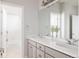 Bright bathroom features double sinks, gray cabinets, a large mirror, and a separate room with a shower and tub at 27653 E Euclid Dr, Aurora, CO 80016