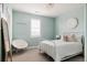 Stylish bedroom featuring a white metal frame bed, and a cozy chair in front of a window with white blinds at 27653 E Euclid Dr, Aurora, CO 80016