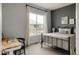 Comfortable bedroom featuring a large window, a desk area, and neutral decor at 27653 E Euclid Dr, Aurora, CO 80016