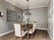 Dining room features a modern chandelier, seating for eight, and dark wood flooring at 27653 E Euclid Dr, Aurora, CO 80016