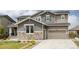 Charming two-story home with a stone and siding exterior, a well-manicured lawn, and an attached two-car garage at 27653 E Euclid Dr, Aurora, CO 80016