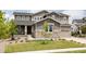 Charming two-story home featuring stone accents, a covered porch, and a well-maintained front yard at 27653 E Euclid Dr, Aurora, CO 80016