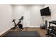 Home gym equipped with an exercise bike, free weights, and a mounted TV for a complete workout experience at 27653 E Euclid Dr, Aurora, CO 80016
