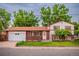 Charming two-story home with brick and white siding, a well-maintained lawn, and an attached two car garage at 1583 Skeel St, Brighton, CO 80601
