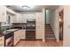 Functional kitchen featuring white cabinets, black countertops, modern appliances, and easy access to the staircase at 1583 Skeel St, Brighton, CO 80601