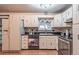 Well-lit kitchen featuring white cabinets, black countertops, modern appliances, and stylish tile backsplash at 1583 Skeel St, Brighton, CO 80601