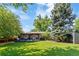 A large backyard features a deck, lush lawn, mature trees, and a wooden fence at 5525 E Bails Dr, Denver, CO 80222