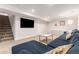 Spacious basement features a plush sofa, TV, and a staircase leading to another level at 5525 E Bails Dr, Denver, CO 80222