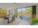 Open dining space with sliding doors to outdoor seating area, modern table, stylish chairs, and lush landscaping at 5525 E Bails Dr, Denver, CO 80222