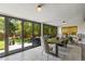 Dining room with oversized sliding glass doors to the outdoor space; table with seating and contemporary lighting at 5525 E Bails Dr, Denver, CO 80222