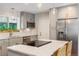 Charming kitchen features stainless steel appliances, gray cabinets, stylish pendant lights, island with cooktop and seating at 5525 E Bails Dr, Denver, CO 80222