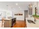 Bright kitchen with stainless steel appliances, gray cabinets, hardwood floors, opening to living room and outdoor space at 5525 E Bails Dr, Denver, CO 80222