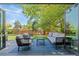 Outdoor living space with comfortable seating, a dark wood deck, a manicured lawn, mature trees, and privacy fence at 5525 E Bails Dr, Denver, CO 80222