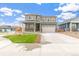 Well-maintained two-story home boasts a spacious driveway, manicured lawn and inviting curb appeal at 2206 Crosswind St, Fort Lupton, CO 80621
