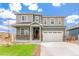 Charming two-story home featuring stone accents, a well-manicured lawn, and a convenient two-car garage at 2206 Crosswind St, Fort Lupton, CO 80621