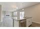 Kitchen island featuring a sink, dishwasher, and modern cabinets is open to a living space at 2206 Crosswind St, Fort Lupton, CO 80621