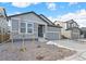 Two-story house with gray siding, stone accents, and a two-car garage at 13412 E 110Th Way, Commerce City, CO 80022