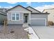 Gray exterior boasts a two-car garage and stone accents at 13412 E 110Th Way, Commerce City, CO 80022