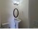 Powder room featuring a pedestal sink, a round mirror, and a commode at 1653 Valley Oak Ct, Castle Rock, CO 80104
