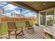 Relaxing covered back porch with rocking chairs, offering a view of the fenced backyard and blue skies at 16341 Clayton St, Thornton, CO 80602