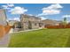 Spacious backyard features green grass, a patio, and a home with solar panels on the roof at 16341 Clayton St, Thornton, CO 80602