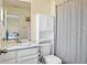 Bathroom showcases a marble countertop vanity, toilet with storage, and shower with patterned curtain at 16341 Clayton St, Thornton, CO 80602